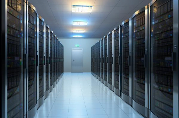 A brightly lit Data Center Room with two rows of server racks on each side, and a closed door at the end of the aisle.