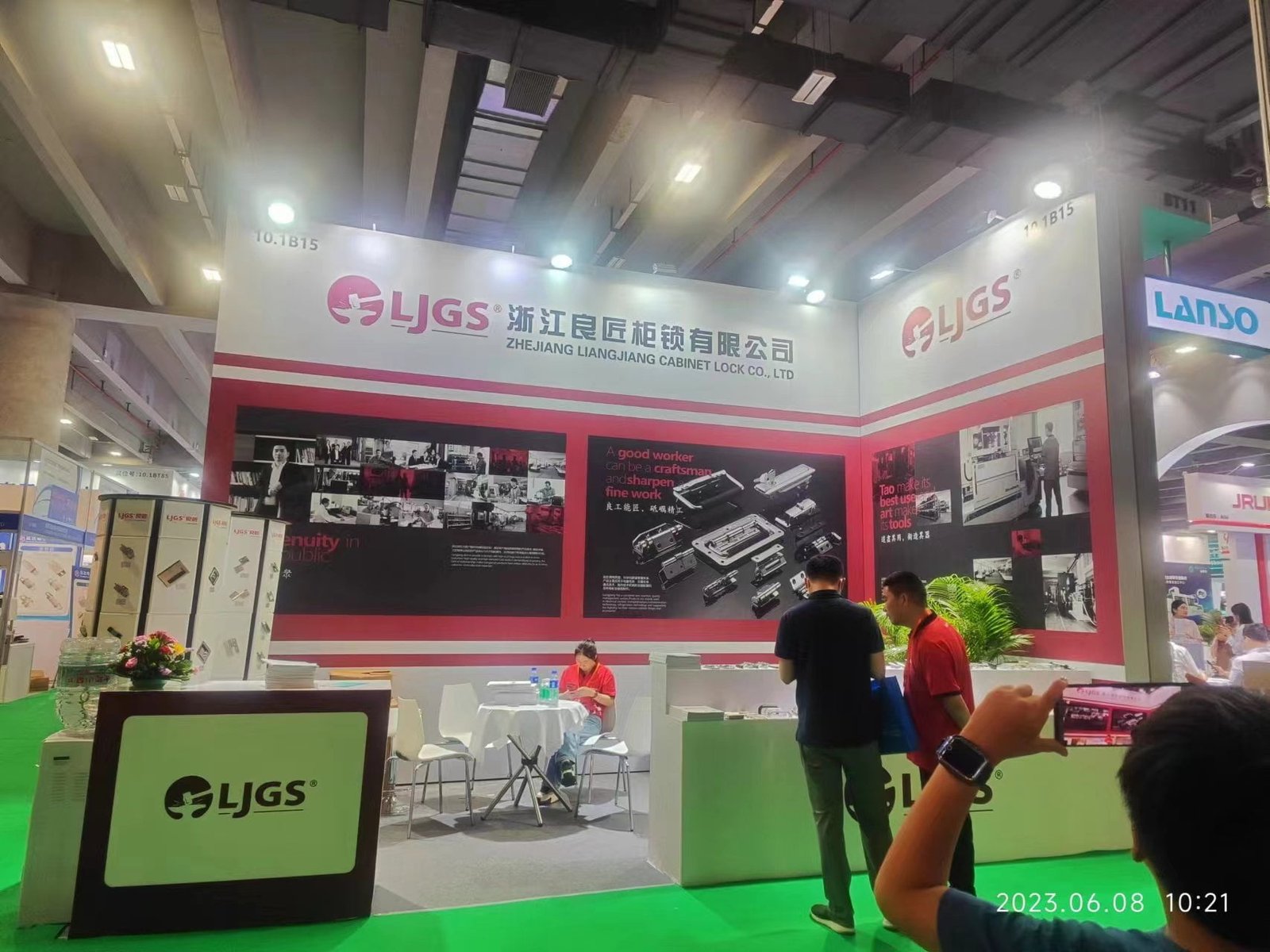 An exhibition booth for Zhejiang LiangJiang Cabinet Lock Co., Ltd. at the Guangzhou Electric Power Exhibition showcases their featured product, guangjiaohui, along with other locks and security products. Visitors and staff are present, with marketing materials displayed throughout the booth.