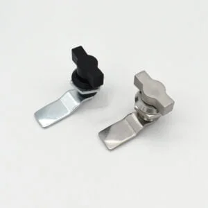 On a white background are two metal cam locks from model 714, one with a sleek black knob and the other featuring a stylish silver knob.