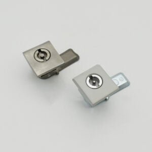DSC_2317 showcases a pair of square cam locks featuring sleek metal finishes, artfully displayed against a simple white backdrop.