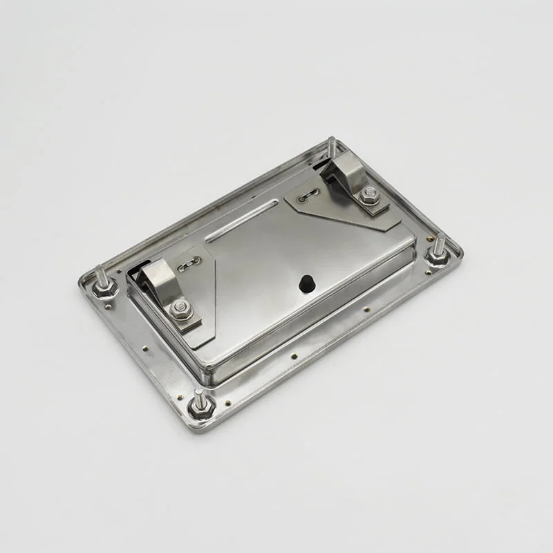 The 83a4fdfc9ed8ab4e8fa51e81fa6007a, a rectangular metal electrical enclosure with a hinged lid secured by screws at the corners, sits on a plain white surface.