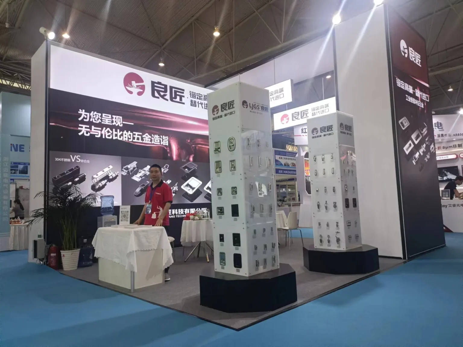 At the Chengdu Electric Power Industry Exhibition, Liangjiang Cabinet Lock Co., Ltd.'s booth prominently features three display columns presenting their metal parts and machinery. A representative stands behind a table stocked with brochures as overhead banners display Chinese text celebrating industry advancements.
